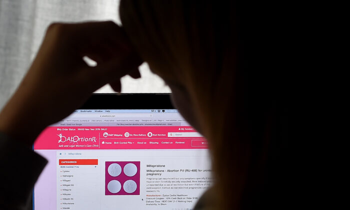 Una mujer mira una píldora abortiva (RU-486) mostrada en un computador el 8 de mayo de 2020, en Arlington, Virginia. (Olivier Douliery/AFP vía Getty Images)
