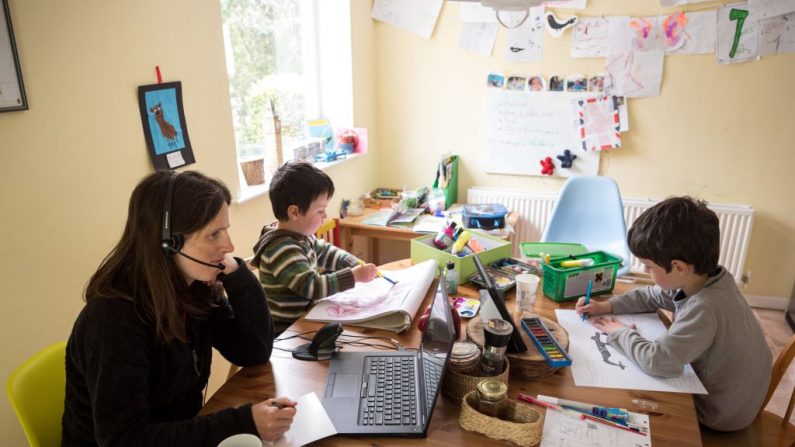Leo (de), de 6 años, y Espen, de 3 años, realizan actividades de educación en casa sugeridas por el sitio web de aprendizaje en línea de su escuela infantil mientras su madre Moira, trabaja desde su casa en la aldea de Marsden, cerca de Huddersfield, en el norte de Inglaterra, el 15 de mayo de 2020. (OLI SCARFF/AFP vía Getty Images)