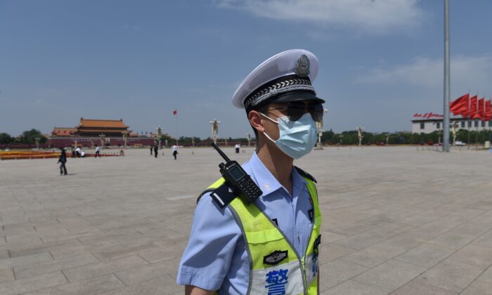 Un policía patrulla en la Plaza de Tiananmen antes de la sesión de clausura del Congreso Nacional del Pueblo en el adyacente Gran Salón del Pueblo en Beijing el 28 de mayo de 2020 (Nicolas Asfouri / AFP a través de Getty Images).