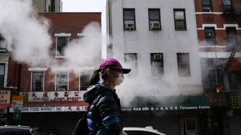 Mujer camina por una calle del barrio chino mientras el coronavirus mantiene cerrados los mercados financieros y los negocios en su mayoría el 21 de abril de 2020 en la ciudad de Nueva York. (Foto de Spencer Platt/Getty Images)