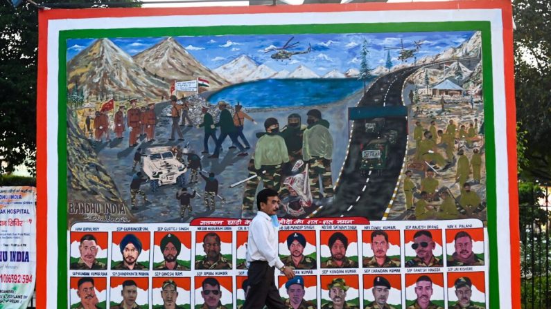 Un hombre pasa junto a un cartel que muestra retratos de soldados indios muertos en una pelea cuerpo a cuerpo con sus homólogos chinos en Ladakh el 15 de junio, en un área de mercado en Nueva Delhi el 31 de agosto de 2020. (Jewel Samad/AFP a través de Getty Images)