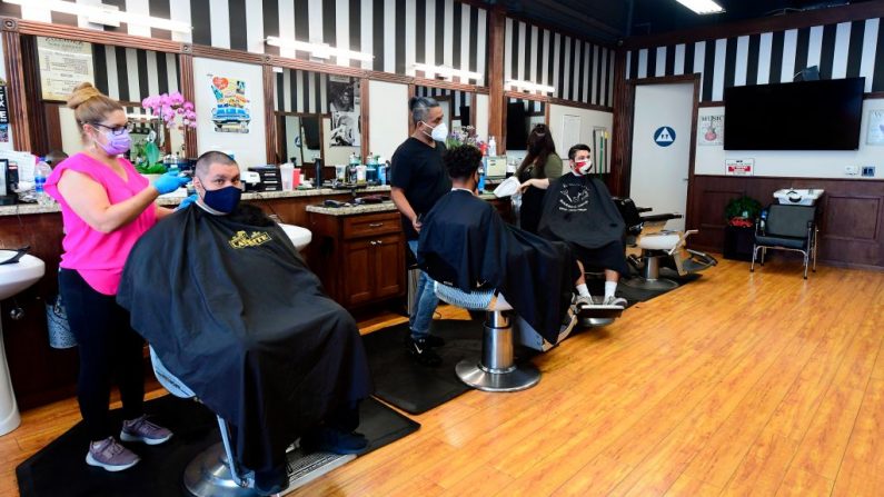 Los peluqueros trabajan con los clientes en el interior de sus locales por primera vez en meses, en Angelo's Barber Shop, en el centro de Los Ángeles, California, el 3 de septiembre de 2020. (Frederic J. Brown/AFP a través de Getty Images).