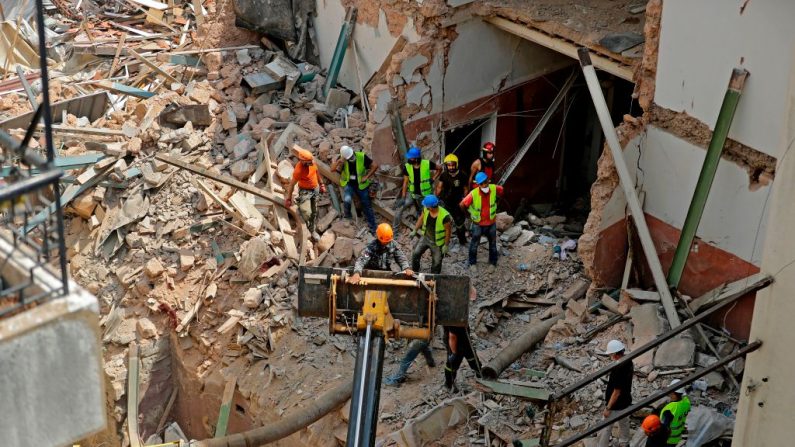 Trabajadores de rescate excavan entre los escombros de un edificio muy dañado en la capital del Líbano, Beirut, en busca de posibles supervivientes de una mega explosión en el puerto adyacente hace un mes, después de que los escáneres detectaran un pulso, el 4 de septiembre de 2020. (Foto de JOSEPH EID/AFP vía Getty Images)