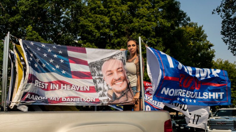 Rebecca Thomas, participante en un mitin de caravanas pro-Trump, posa con una bandera en memoria de Aaron Jay Danielson, el 7 de septiembre de 2020, en Salem, Oregon. (David Ryder/Getty Images)