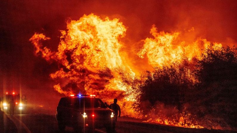 Un oficial de la ley observa cómo las llamas se lanzan al aire mientras el fuego continúa extendiéndose en el incendio del Oso en Oroville, California (EE.UU.), el 9 de septiembre de 2020. (Foto de JOSH EDELSON/AFP vía Getty Images)