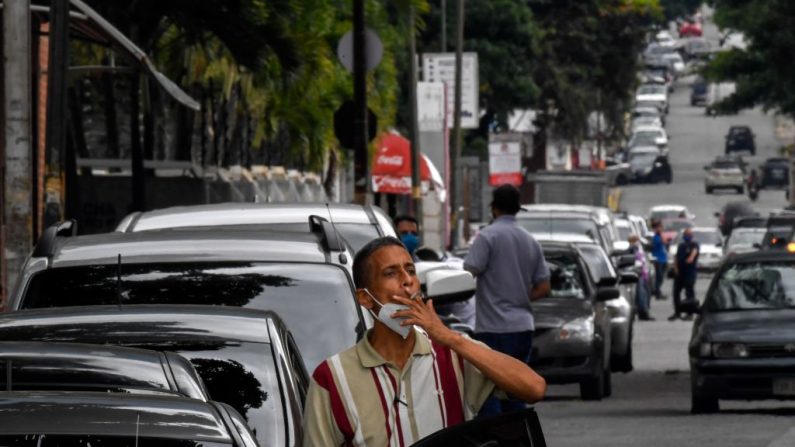 Un hombre fuma mientras hace cola para rellenar el depósito de su coche fuera de una gasolinera del barrio de Chacao en Caracas (Venezuela) el 11 de septiembre de 2020, en medio de la nueva pandemia del COVID-19. (Foto de FEDERICO PARRA/AFP vía Getty Images)