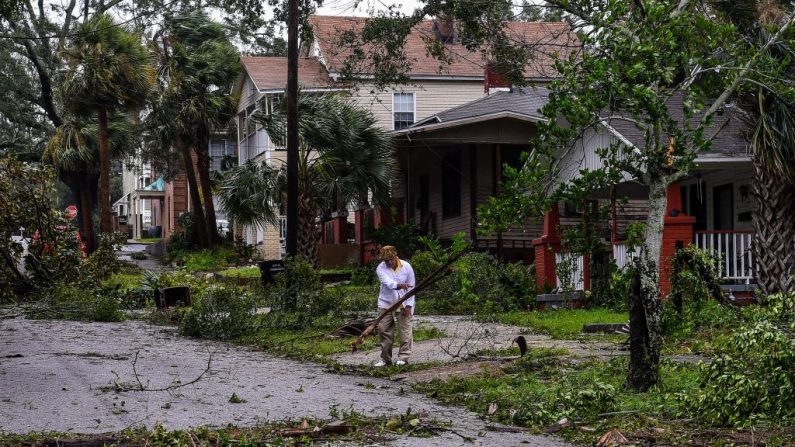 Mark Robinson quita la rama de un árbol después del huracán Sally fuera de la casa en Pensacola, Florida (EE.UU.) el 16 de septiembre de 2020. (Chandan Khanna/AFP vía Getty Images)