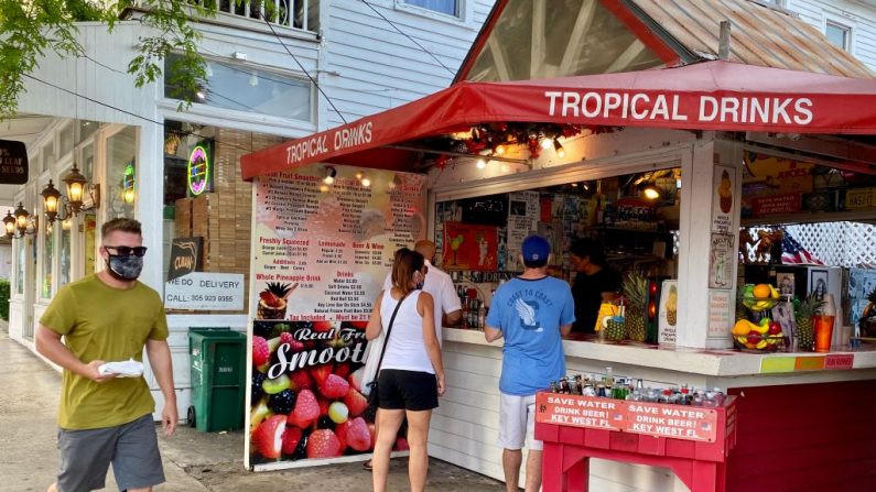 Un hombre con mascarilla camina por un bar al aire libre en la calle Duval en Key West, Florida el 17 de septiembre de 2020 en medio de la pandemia de COVID-19. (Foto de DANIEL SLIM/AFP vía Getty Images)