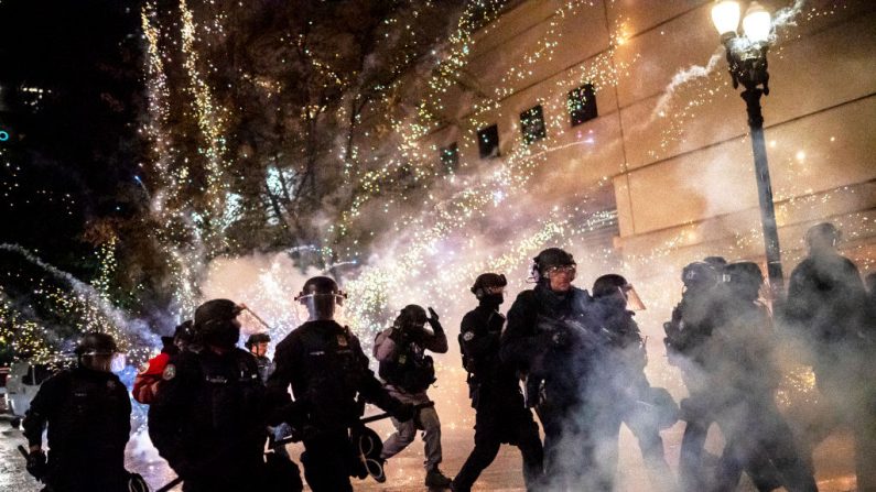 La policía de Portland reacciona cuando un petardo explota detrás de su línea policial en las violentas protestas y revueltas de Portland el 23 de septiembre de 2020. (Nathan Howard/Getty Images)