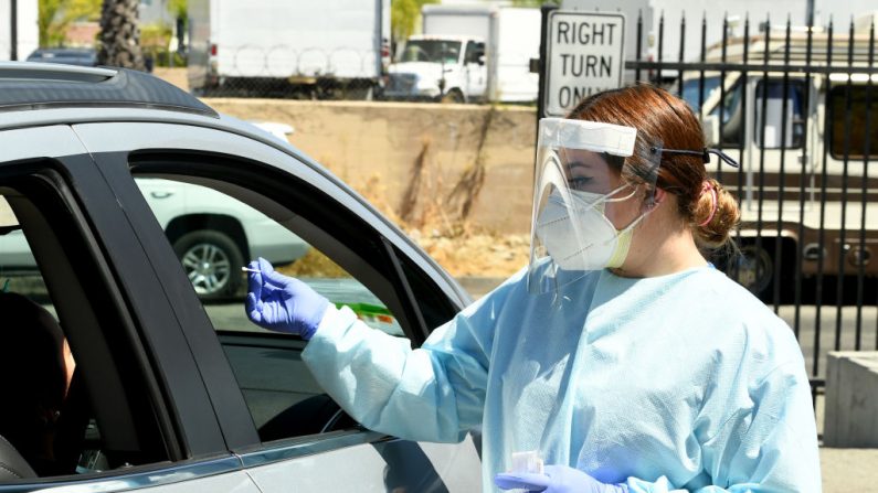 Los trabajadores de atención de urgencia, que usan equipo de protección personal (PPE), realizan la prueba COVID-19 en la escuela secundaria Central City Value, el 31 de julio de 2020, en los Ángeles, California. (Kevin Winter/Getty Images)