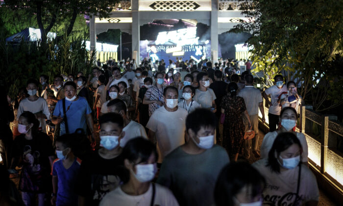 Los residentes de Wuhan, provincia de Hubei, China, usan mascarillas mientras caminan por la entrada del Festival de la Cerveza el 21 de agosto de 2020. (Getty Images)