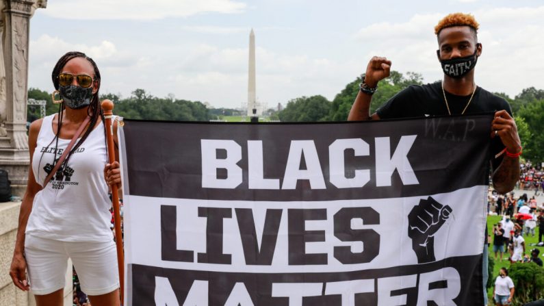 Los manifestantes sostienen un cartel en apoyo de Black Lives Matter durante la Marcha del Compromiso en Washington, DC el 28 de agosto de 2020. (Natasha Moustache/Getty Images)