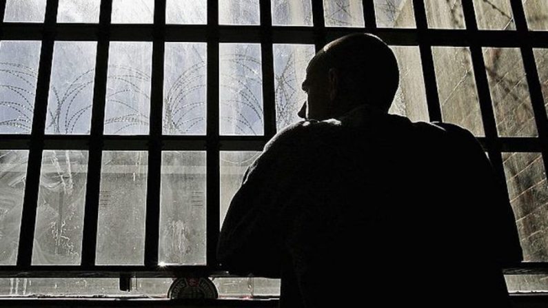 Un joven preso mira desde los barrotes de la prisión en una foto de archivo. (Peter Macdiarmid/Getty Images)