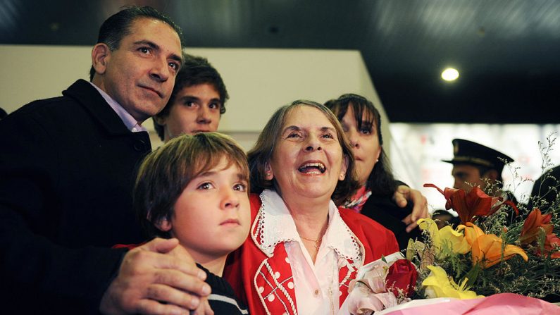 El periodista Roberto Quiñones (i) junto a su madre, la disidente cubana Hilda Molina (c), sus hijos Juan Pablo (delante) y Roberto (arriba 2º i), y su esposa Verónica Scarpatti (d) en el aeropuerto de Ezeiza en Buenos Aires, Argentina, el 14 de junio de 2009. (DANIEL GARCÍA/AFP a través de Getty Images)