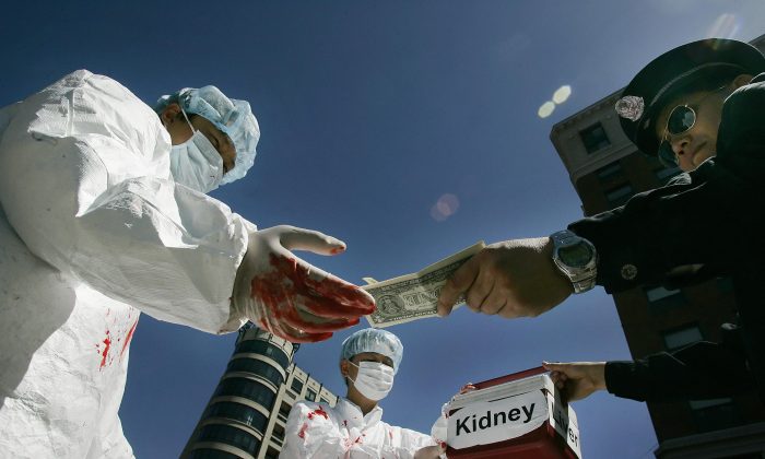 Activistas chinos dramatizan un acto ilegal de pago por órganos humanos durante una protesta el 19 de abril de 2006 en Washington, D.C. (Jim Watson/AFP vía Getty Images)