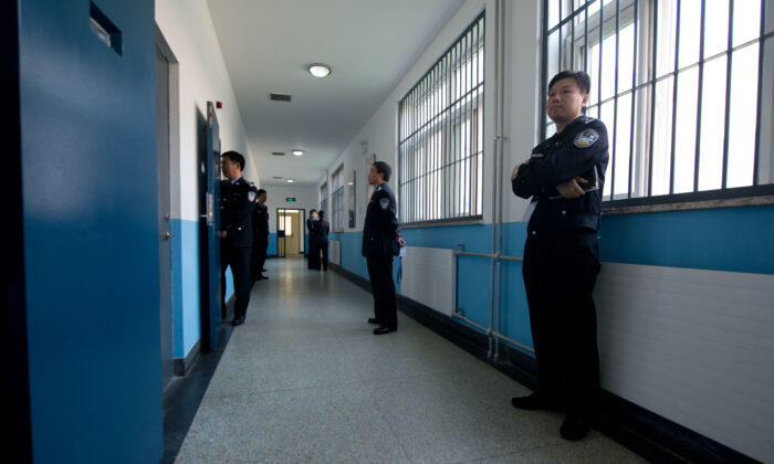 Los guardias de la policía se paran en un pasillo dentro del Centro de Detención No.1, durante una visita guiada por el gobierno en Beijing, el 25 de octubre de 2012. (Ed Jones/AFP a través de Getty Images).