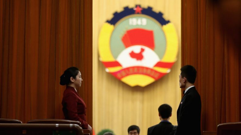 Una anfitriona se para junto a la cortina mientras los delegados ingresan a la sala de reuniones antes de la sesión plenaria de la Conferencia Consultiva Política del Pueblo Chino en el Gran Salón del Pueblo en Beijing, China, el 11 de marzo de 2013 (Feng Li/Getty Images)