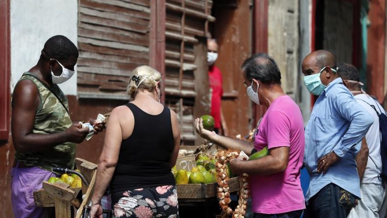 Varias personas compran alimentos a un vendedor ambulante, el 17 de septiembre de 2020 en La Habana (Cuba). EFE/ Ernesto Mastrascusa