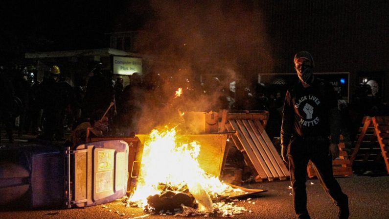 Un hombre camina junto a un fuego provocado en la calle por alborotadores en Portland, Ore., el 5 de septiembre de 2020. (Allison Dinner/AFP vía Getty Images)