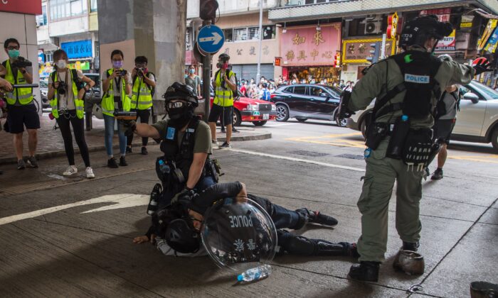 Un policía antidisturbios detiene a un hombre mientras dispersa a los manifestantes que participan en un mitin contra la nueva ley de seguridad nacional en Hong Kong, el 1 de julio de 2020. (Dale de la Rey/AFP a través de Getty Images)