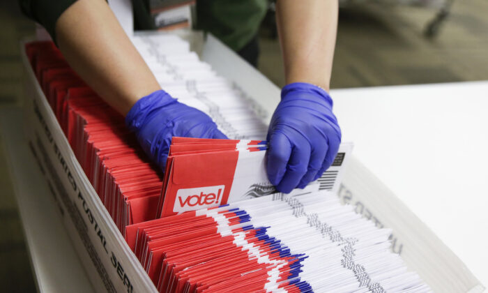 Los trabajadores electorales de Estados Unidos clasifican las boletas de voto por correo para la primaria presidencial en las elecciones del condado de King en Renton, Washington, el 10 de marzo de 2020. (Jason Redmond/AFP vía Getty Images)