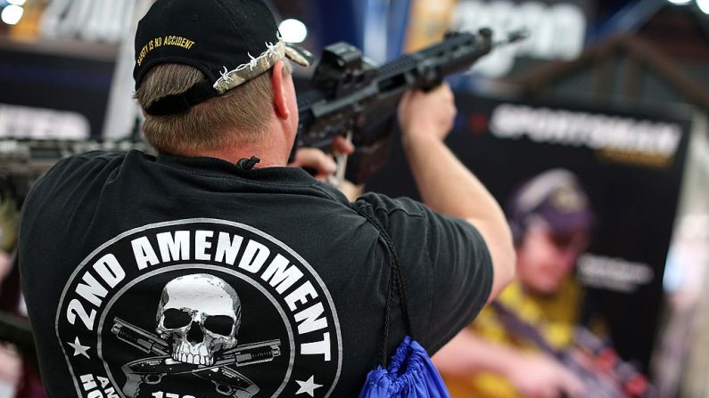 Un asistente usa una playera de la 2ª enmienda mientras inspecciona un rifle de ataque durante la Reunión Anual de la NRA el 5 de mayo de 2013 en Houston, Texas.  ( Justin Sullivan/Getty Images)