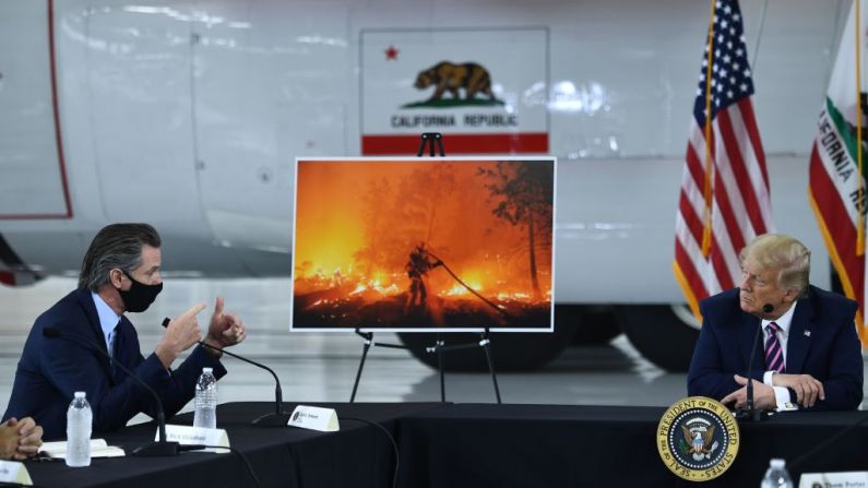 El presidente de Estados Unidos, Donald Trump habla con el gobernador de California, Gavin Newsom (D-Calif.), en el Aeropuerto McClellan de Sacramento, en McClellan Park, California, el 14 de septiembre de 2020 durante una sesión informativa sobre incendios forestales. (BRENDAN SMIALOWSKI/AFP a través de Getty Images)