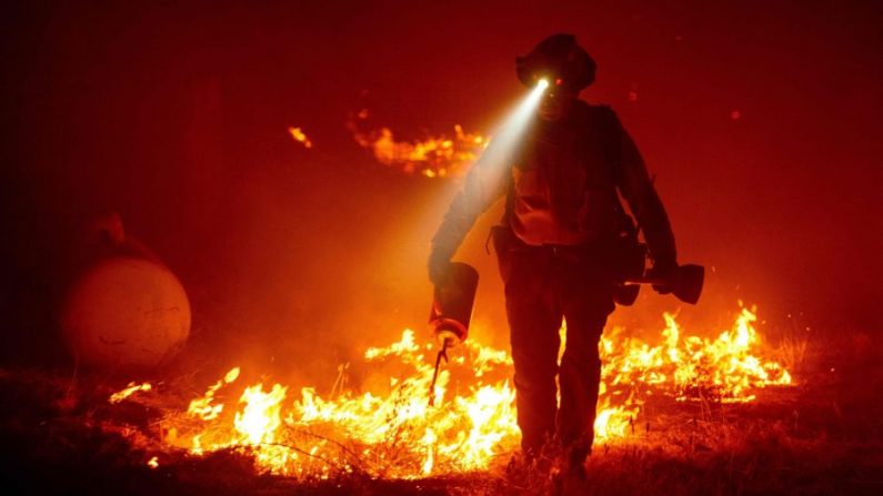 Los bomberos cortaron las líneas defensivas y encendieron fuegos para proteger varios edificios detrás de una estación de bomberos de CalFire durante el incendio de Bear, que forma parte de los incendios del North Lightning Complex en el área de Berry Creek del condado no incorporado de Butte, California, el 9 de septiembre de 2020. (Josh Edelson/AFP vía Getty Images)