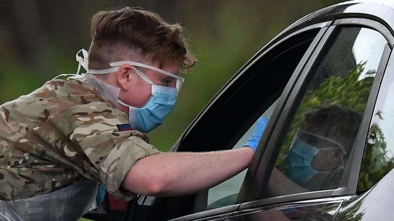 Un miembro de las fuerzas armadas hace prueba a un trabajador del virus del PCCh en una instalación de pruebas en el Chessington World of Adventures Resort en Greater Londres, Inglaterra, el 28 de abril de 2020. (BEN STANSALL/AFP vía Getty Images)