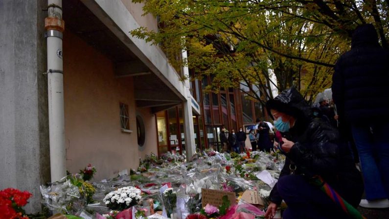 Flores y mensajes a las puertas de instituto en el que trabajaba el profesor asesinado el 16 de octubre de 2020 en París, Francia. EFE/EPA/JULIEN DE ROSA