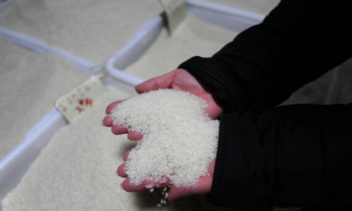 Una vendedora recoge arroz en su puesto en un mercado de Beijing. Durante décadas, los altos niveles de cadmio y otros metales pesados tóxicos han contaminado las vías fluviales de China y a través del riego terminaron en los arrozales de las aldeas. (Peter Parks/Getty Images)