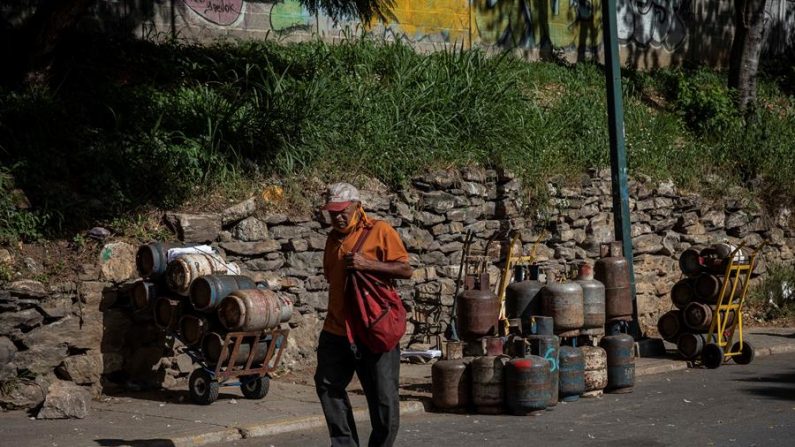 Un hombre camina frente a bombonas vacías de gas, el 27 de octubre de 2020, en Caracas (Venezuela). EFE/ Rayner Pena R