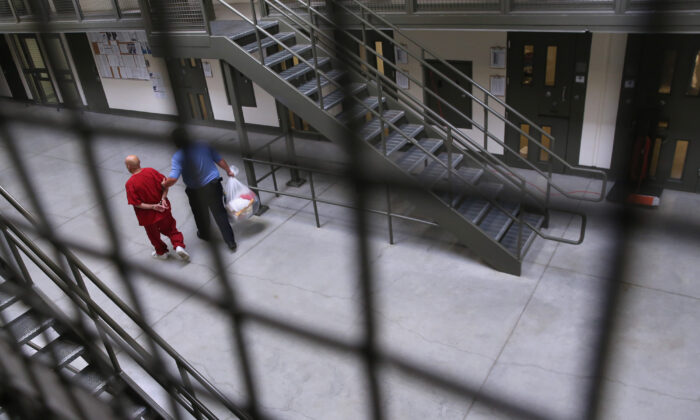 Un guardia escolta a un detenido a la población general en el centro de detención de Adelanto, en Adelanto, California, el 15 de noviembre de 2013. (John Moore/Getty Images)