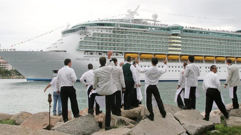 Un grupo de camareros observa la partida del crucero "Freedom of the Seas", el más grande del mundo, que atracó por breves horas en el puerto de Miami, Florida (EEUU). EFE/John Riley/Archivo