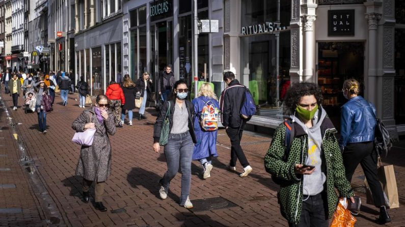 Las personas con máscaras faciales caminan por una calle comercial en el centro de Ámsterdam (Países Bajos) el 11 de octubre de 2020. (Foto de RAMON VAN FLYMEN/ANP/AFP vía Getty Images)