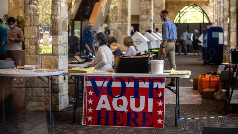Trabajadores electorales ayudan a los votantes dentro de un centro de votación el 13 de octubre de 2020 en Austin, Texas (EE.UU.). (Foto de Sergio Flores/Getty Images)