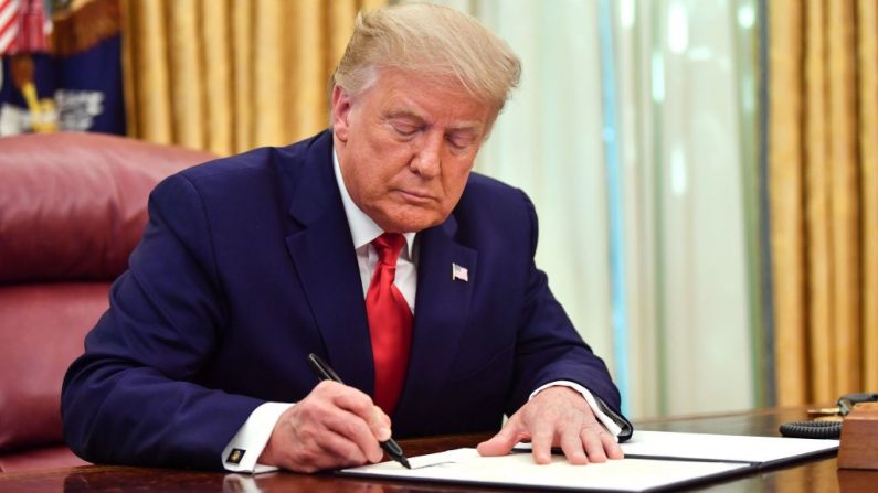 El presidente de Estados Unidos, Donald Trump, firma el perdón para Alice Johnson, en el Despacho Oval de la Casa Blanca en Washington, DC, el 28 de agosto de 2020. (Foto de NICHOLAS KAMM/AFP vía Getty Images)