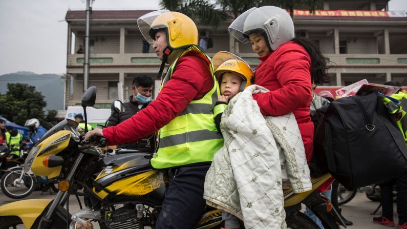Una familia de trabajadores migrantes chinos descansa en una gasolinera después de andar en motocicleta el 25 de enero de 2019 en Zhaoqing, provincia de Guangdong, China. Más del 30 por ciento de las familias chinas se enfrentan a la violencia doméstica, que es la principal causa de suicidios femeninos en la China rural. (Wang He/Getty Images) 
