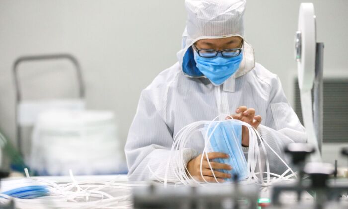 Un trabajador produce mascarillas protectoras en una fábrica en Qingdao, China, el 6 de febrero de 2020. (STR/AFP a través de Getty Images).
