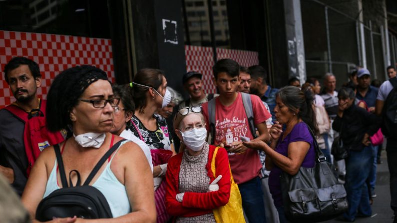 La gente hace cola para entrar en un supermercado ante la pandemia global del COVID-19, en Caracas (Venezuela), el 13 de marzo de 2020. (Foto de CRISTIAN HERNANDEZ/AFP vía Getty Images)