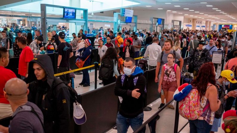 Los viajeros hacen cola en un control de seguridad en el aeropuerto internacional Luis Muñoz Marín de San Juan, Puerto Rico, el 18 de marzo de 2020. (Ricardo Arduengo/AFP vía Getty Images)