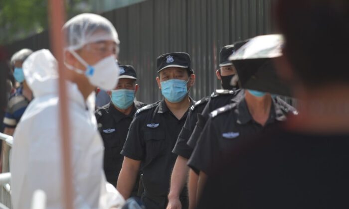 Unos guardias de seguridad esperan en una cola para someterse a las pruebas de hisopado del coronavirus en Beijing el 30 de junio de 2020. (Greg Baker/AFP vía Getty Images)
