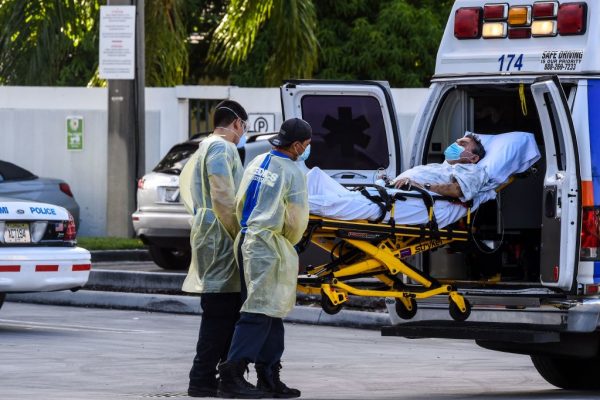 Los médicos trasladan a un paciente en camilla desde una ambulancia fuera de la sala de emergencias del Coral Gables Hospital donde los pacientes con el covid-19 son tratados en Coral Gables, cerca de Miami (EE.UU.), el 30 de julio de 2020. (Foto de CHANDAN KHANNA/AFP vía Getty Images)