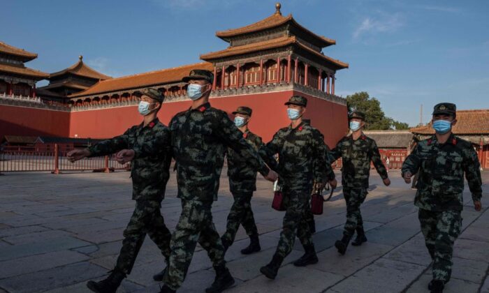 Oficiales de policía paramilitar de China marchan con mascarillas junto a la entrada de la Ciudad Prohibida en Beijing el 20 de septiembre de 2020. (Nicolas Asfouri/AFP vía Getty Images)