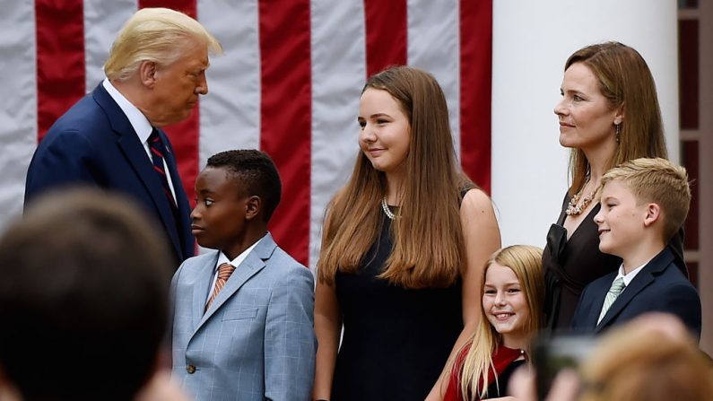 El presidente Donald Trump se acerca a la familia de la jueza Amy Coney Barrett (dcha.) durante un acto en la Rosaleda de la Casa Blanca el 26 de septiembre de 2020. (Foto de OLIVIER DOULIERY/AFP vía Getty Images)