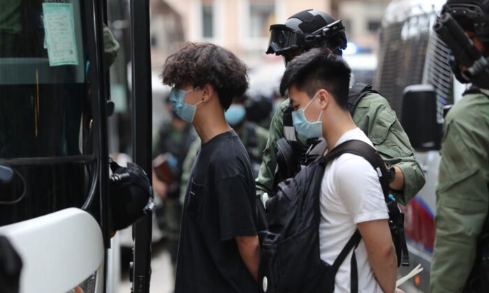 La policía escolta a una camioneta policial a detenidos después de una manifestación en Hong Kong el 1 de octubre de 2020. (May James/AFP vía Getty Images)
