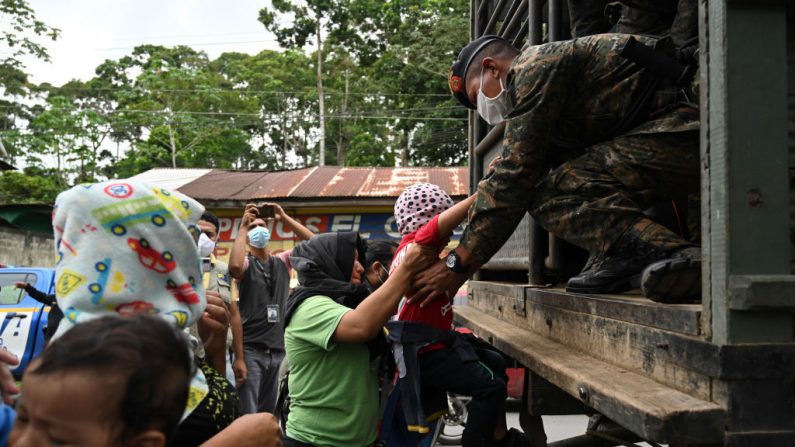 Migrantes hondureños que se dirigían a Estados Unidos, sentados en un camión del ejército guatemalteco después de haber aceptado voluntariamente regresar a Honduras, en Entre Ríos, Guatemala, el 2 de octubre de 2020. (Foto de JOHAN ORDONEZ/AFP vía Getty Images)