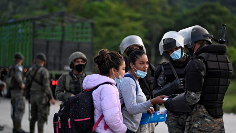 Migrantes hondureños, parte de una caravana con destino a Estados Unidos, son interceptados por miembros del ejército guatemalteco que les piden documentos en San Luis, departamento de Petén, Guatemala, el 3 de octubre de 2020. (Foto de JOHAN ORDONEZ/AFP vía Getty Images)