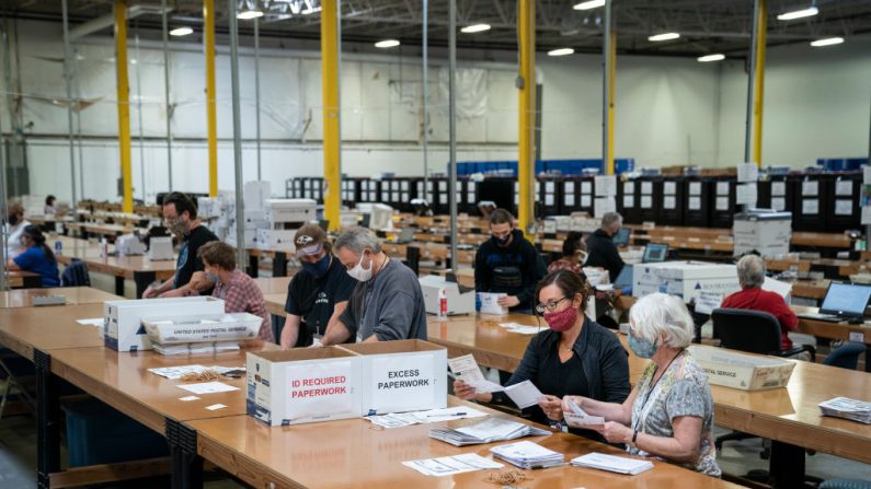 Trabajando en pares bipartidistas, los encuestadores procesan las boletas por correo en un almacén de la sede de la Junta Electoral del Condado de Anne Arundel, el 7 de octubre de 2020, en Glen Burnie, Maryland. (Drew Angerer/Getty Images)