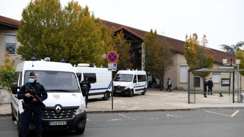Policías franceses de CRS se paran junto a vehículos de CRS frente a una escuela secundaria en Conflans-Sainte-Honorine, 30kms al noroeste de París, el 17 de octubre de 2020, después de que un maestro fuera decapitado por un atacante que fue muerto a tiros por policías. (Bertrand Guay / AFP vía Getty Images)